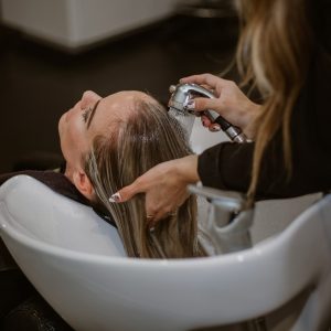a woman getting her hair cut by a hair stylist